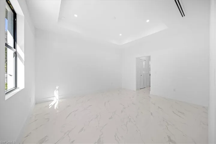 Unfurnished room featuring light marble finish flooring and recessed lighting