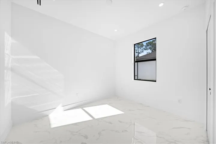 Spare room featuring recessed lighting and light marble finish flooring