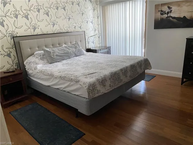 Bedroom featuring baseboards and dark wood-style flooring