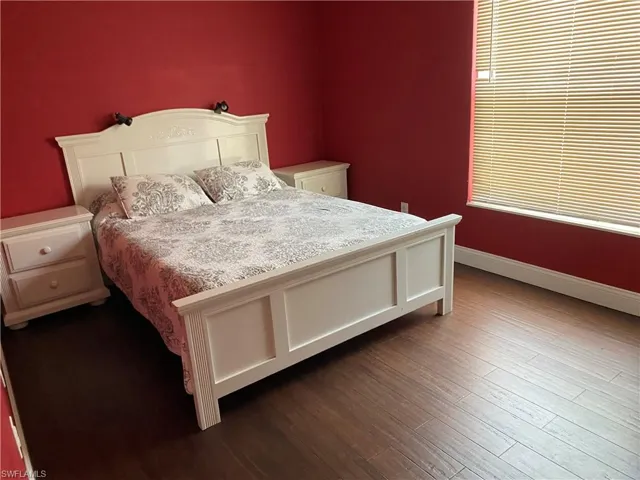 Bedroom featuring baseboards and dark wood-style floors