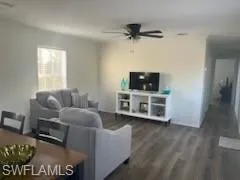 Living area with dark wood finished floors and a ceiling fan