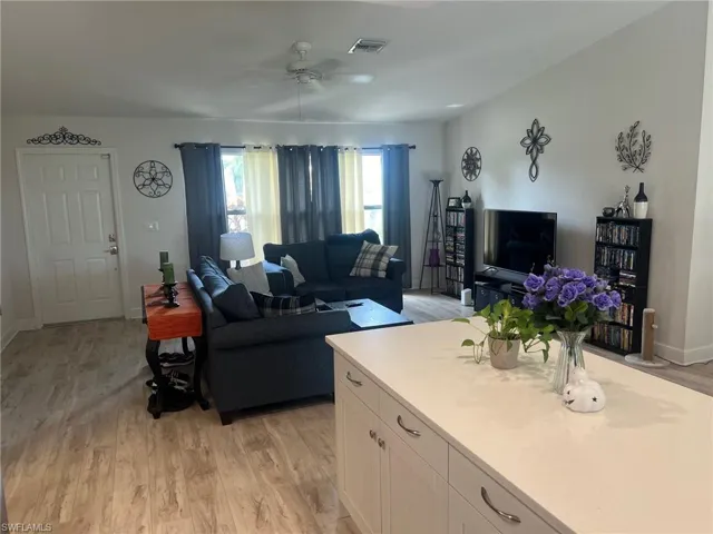 Living room with ceiling fan and light hardwood / wood-style flooring