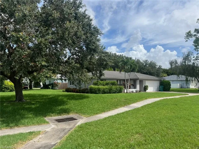 View of front of property with a garage and a front lawn