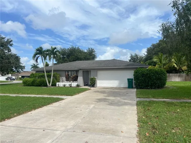Ranch-style home with a garage and a front lawn