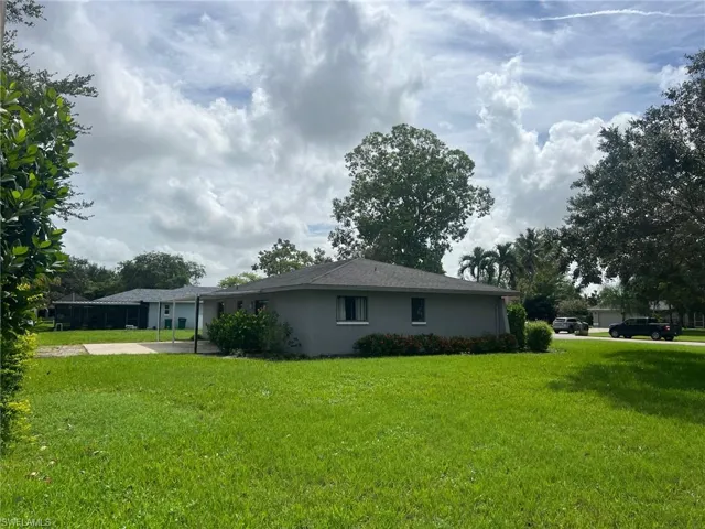 View of side of property featuring a lawn