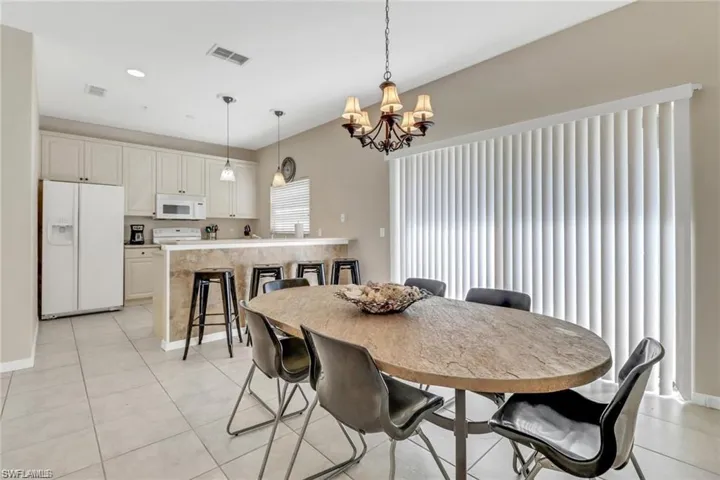Dining area featuring baseboards, visible vents, an inviting chandelier, and light tile patterned flooring
