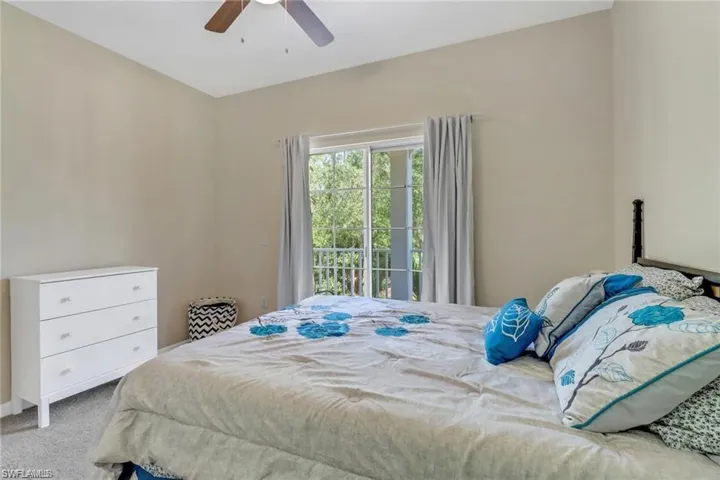 Bedroom featuring access to exterior, light carpet, and a ceiling fan