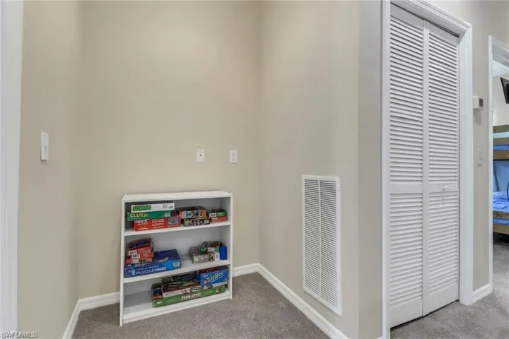 Rec room featuring baseboards, visible vents, and light colored carpet
