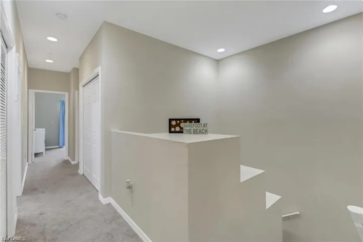Hall featuring baseboards, recessed lighting, an upstairs landing, and light colored carpet