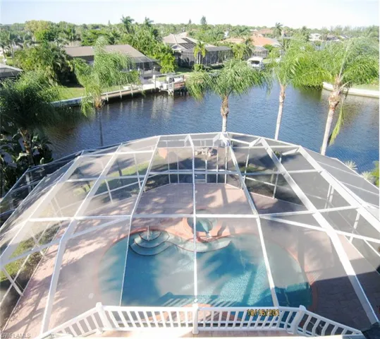 Dock area featuring a water view, a lanai, and a pool with hot tub