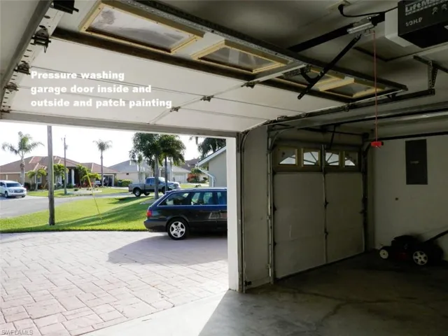 Garage featuring a yard, electric panel, and two garage door opener