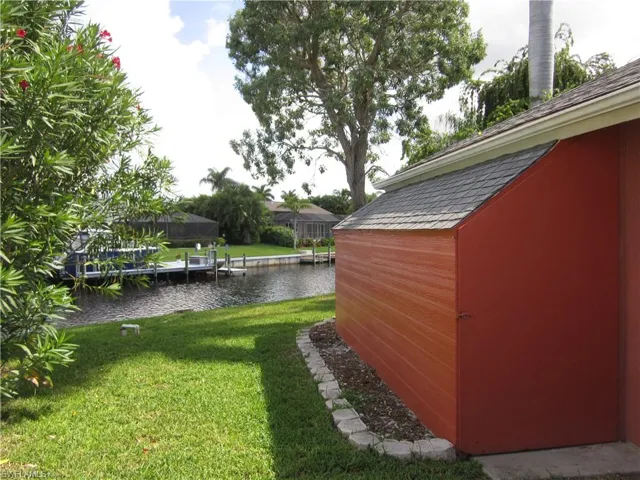 View of yard featuring a water view and a side shed