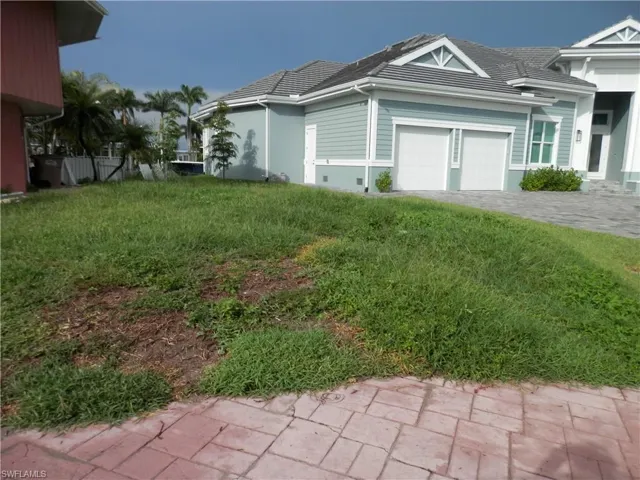 View of new neighbor  property exterior with a lawn and the neighbors garage