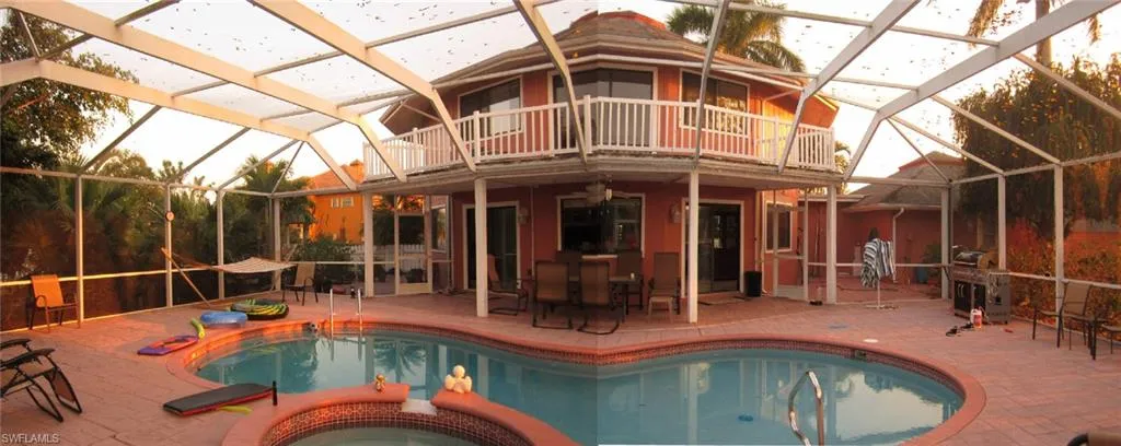 View of pool with the sunset beauty in summer, the patio area, and a lanai
