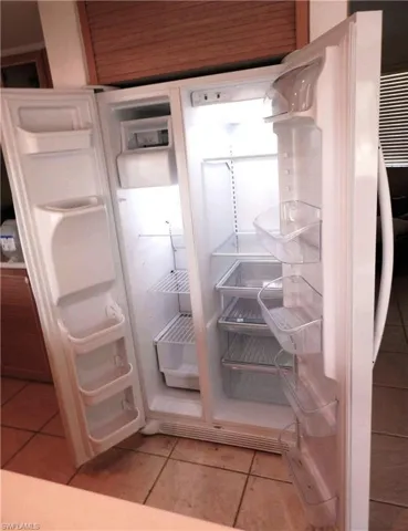 Details with white cabinets and white fridge with ice dispenser