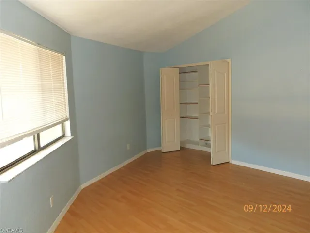 Unfurnished 3rd bedroom with hardwood / wood-style flooring, vaulted ceiling, and a closet