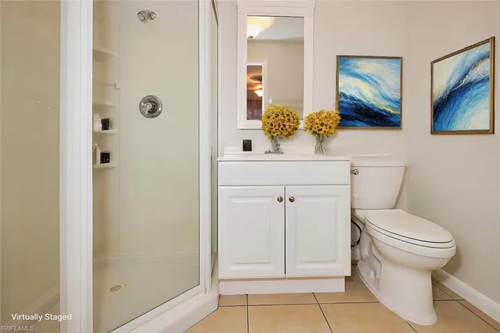 Bathroom with vanity, tile patterned floors, toilet, and walk in shower