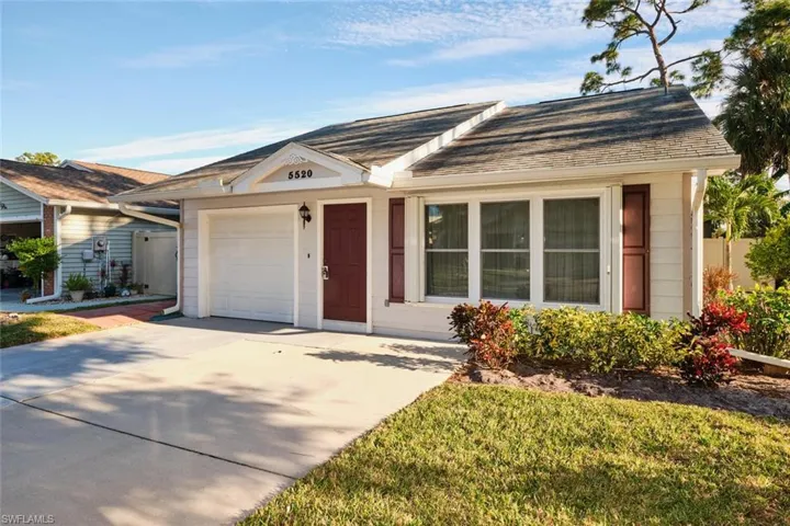 Ranch-style house featuring a garage and a front yard