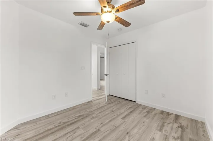 Unfurnished bedroom featuring light wood finished floors, a ceiling fan, and a closet