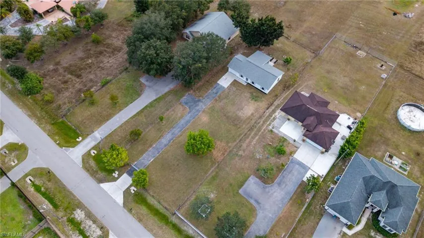 Aerial view of property and surrounding area featuring nearby suburban area