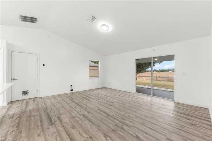 Unfurnished room featuring lofted ceiling and light wood finished floors