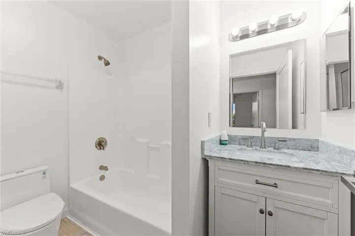Bathroom with vanity, shower / bathtub combination, and light tile patterned floors