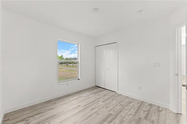 Unfurnished bedroom featuring light wood-type flooring and a closet