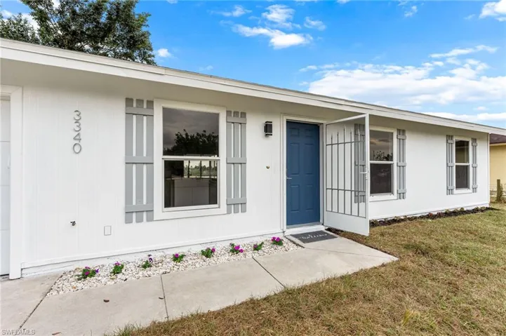 Doorway to property featuring a lawn