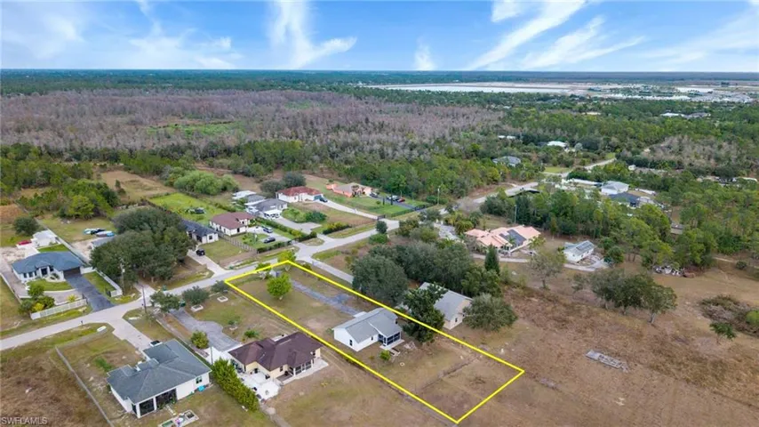 Aerial perspective of suburban area featuring a forest and property boundaries highlighted