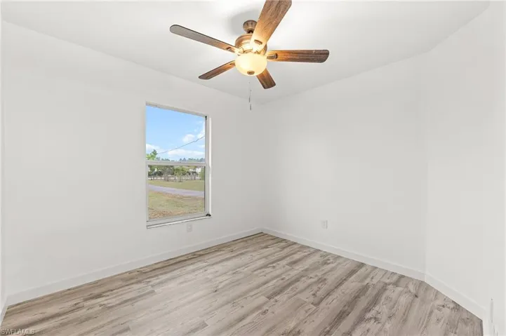 Unfurnished room featuring light wood-type flooring and ceiling fan