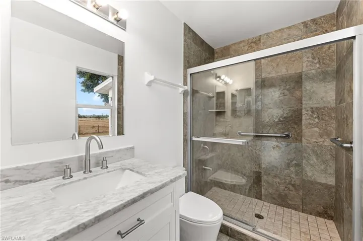 Full bathroom with vanity and a stall shower