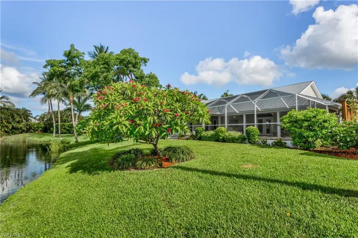 View of green lawn with a lanai and a water view
