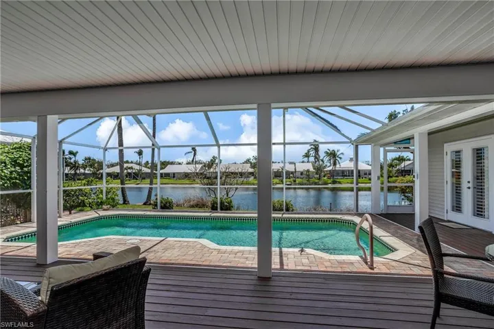 Swimming pool with a deck with water view, a lanai, and a residential view