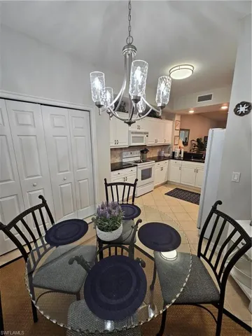 Dining space with a chandelier and light tile patterned flooring
