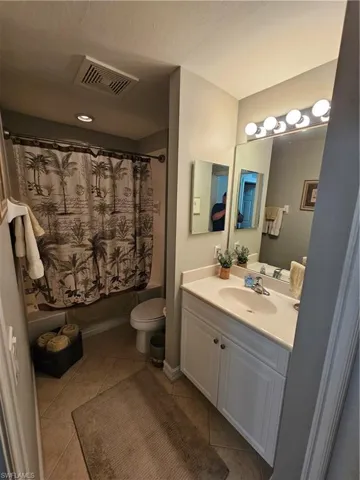 Bathroom featuring vanity, tile patterned flooring, and shower / tub combo