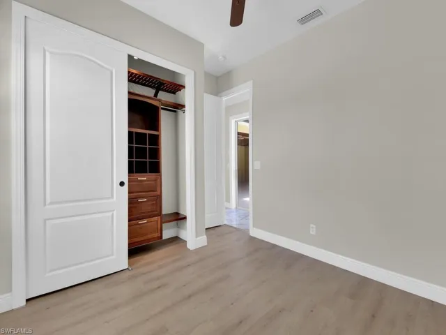 Unfurnished bedroom with light wood-style floors, baseboards, a ceiling fan, and a closet