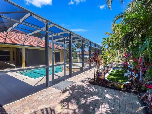 Outdoor pool with a patio area, a ceiling fan, a lanai, and an in-ground hot tub