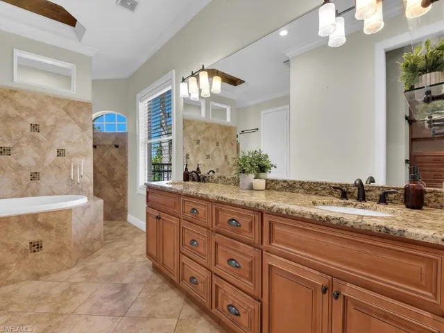 Full bathroom featuring crown molding, walk in shower, tile patterned flooring, double vanity, and tiled tub