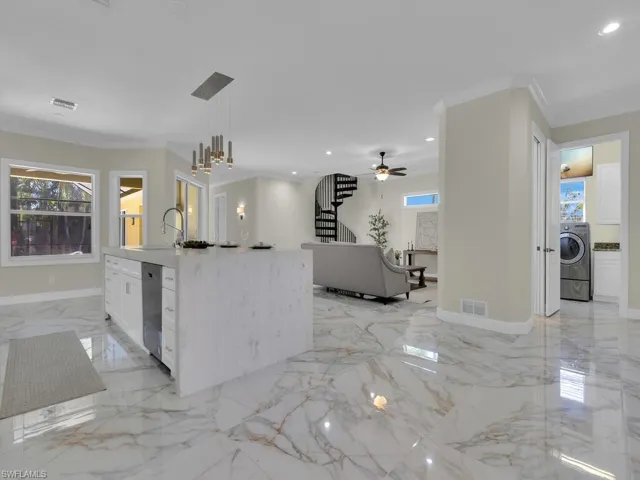 Kitchen featuring washer / dryer, crown molding, plenty of natural light, recessed lighting, and dishwasher
