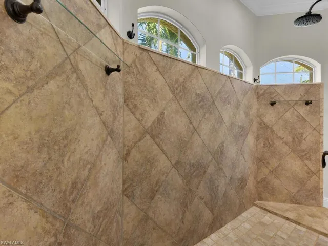 Bathroom view of a tile shower and crown molding