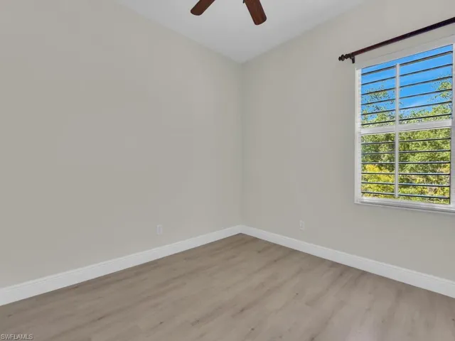 Empty room with light wood-style flooring, baseboards, and ceiling fan