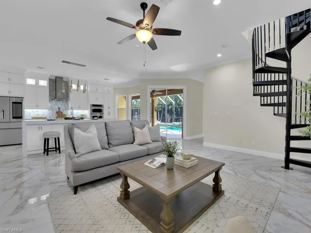 Living area with light marble finish flooring, a ceiling fan, recessed lighting, stairs, and ornamental molding