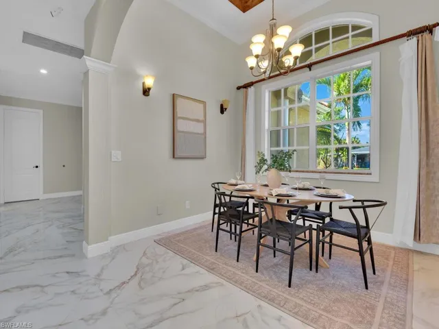 Dining room with a chandelier, marble finish floors, baseboards, crown molding, and recessed lighting