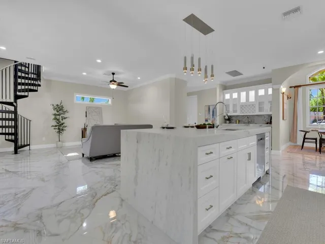 Kitchen with stainless steel dishwasher, light marble finish floors, white cabinets, recessed lighting, and ceiling fan