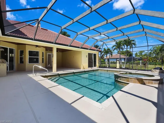 View of pool featuring ceiling fan, a patio, a pool with connected hot tub, and a lanai