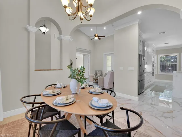 Dining space featuring arched walkways, recessed lighting, a chandelier, baseboards, and ornamental molding