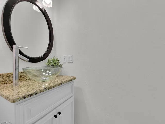 Bathroom with vanity and a textured wall
