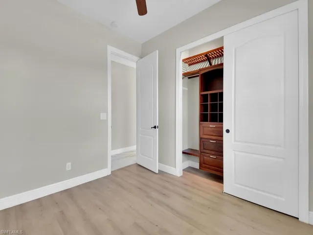 Unfurnished bedroom featuring light wood-type flooring, baseboards, and ceiling fan