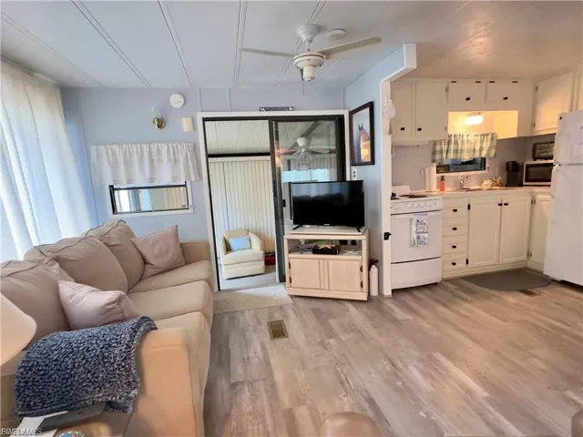 Living area with light wood finished floors and a ceiling fan
