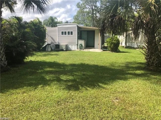 View of grassy yard with a sunroom